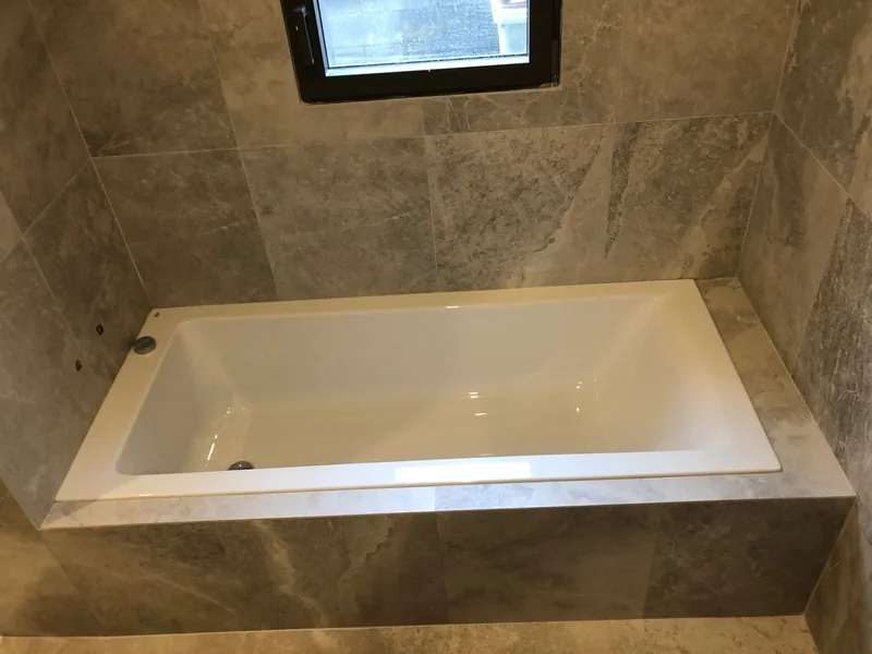 Détail de l’encadrement carrelé et biseauté de la baignoire à Mercurol