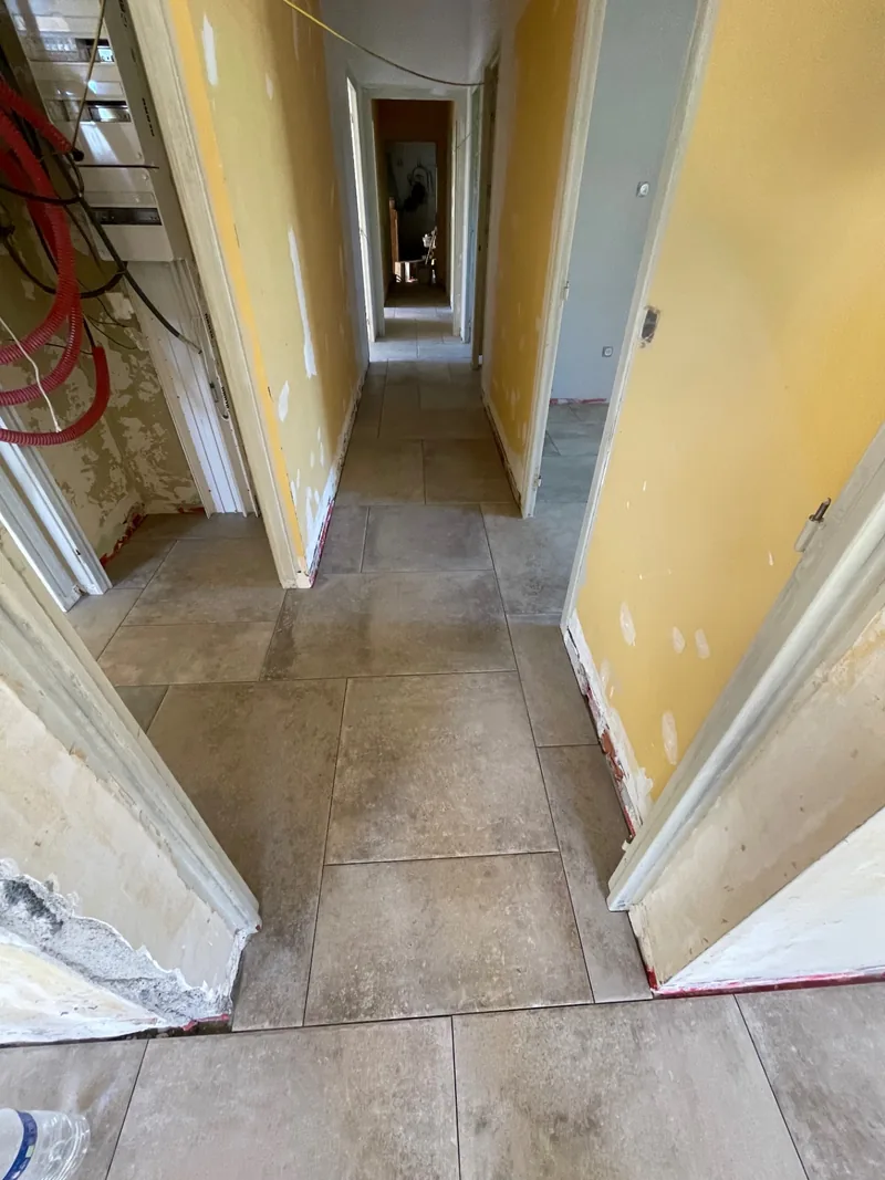 Continuité du carrelage en opus dans le couloir de la maison à Saint-Péray