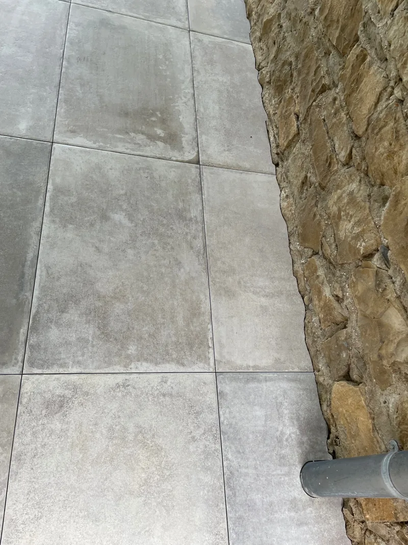 Finition du carrelage 60 × 90 cm le long du mur en pierre