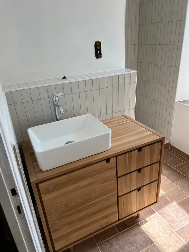 Installation du meuble vasque — Meuble vasque posé devant la faïence murale dans la salle de bain de Saint-Uze