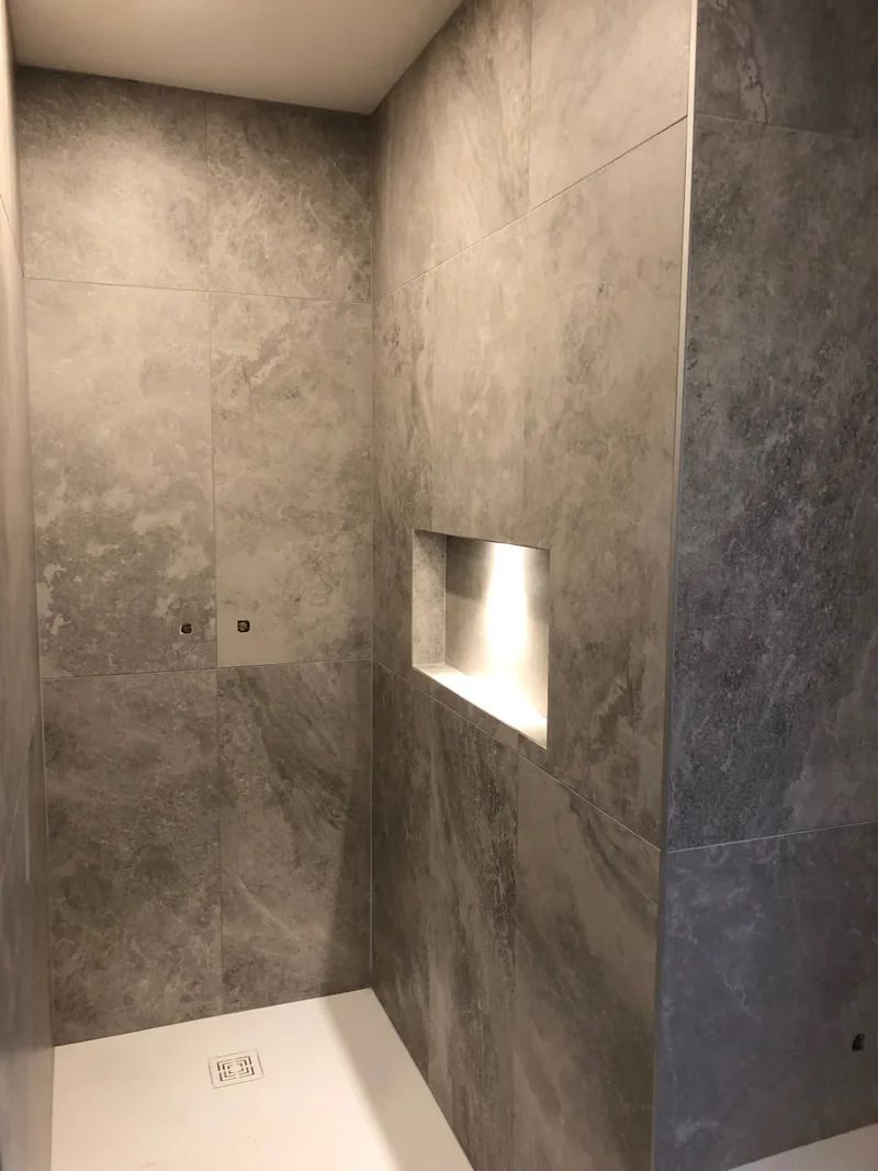 Douche carrelée avec niche éclairée et angles à bords biseautés à Mercurol